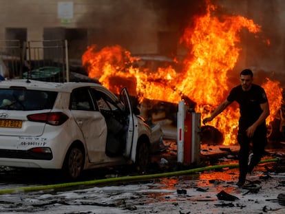 Un hombre huye de un incendio en la ciudad israelí de Ashkelón tras el lanzamiento de cohetes desde Gaza, este sábado.