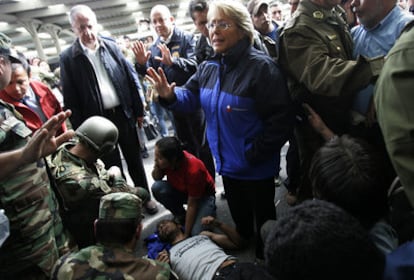 La presidenta de Chile, Michelle Bachelet, al lado de un superviviente del seísmo que sufrió un ataque epiléptico hoy en Concepción