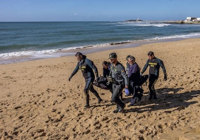 Guardias civiles y empleados funerarios retiran el cuerpo de Ayub tras hallarlo en la playa de Los Caños de Meca (Cádiz).