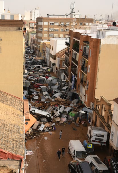 Los coches se apilan en la calle junto a restos de escombros, cortando el paso a los viandantes. En la Comunidad Valenciana continúan las labores de búsqueda de los desaparecidos.