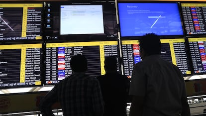 Operarios intentan reparar una pantalla de información en el Aeropuerto Internacional en Nueva Delhi, India, el 19 de julio.