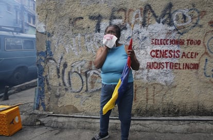 Um manifestante afetado por gás lacrimogêneo cobre seu rosto com um pano.