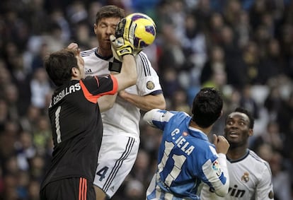 Casillas despeja ante Vela y Xabi Alonso.