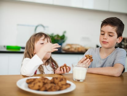 Children enjoying chocolate chip cookies and milk