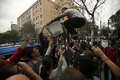 Ciudadanos sacan una urna para esconderla de un colegio de Girona / FRANCISCO SECO (AP)