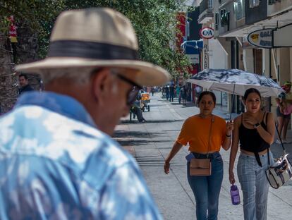 Las personas caminan por la calle con sombrero, gorra o sombrillas por las altas temperaturas en Monterrey (Nuevo León).