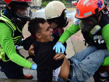 Miembros de la oposición trasladan a un herido.