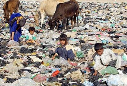 Niños iraquíes buscan entre la basura en una zona de Bagdad.