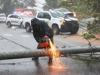 Un trabajador corta un poste de electricidad arruinado por el huracán Fiona, este domingo en Puerto Rico.