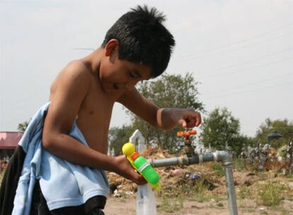 Un niño juega con una pistola de agua en el cementerio de Xicohtzinco, donde han enterrado a la maestra que murió de influenza.