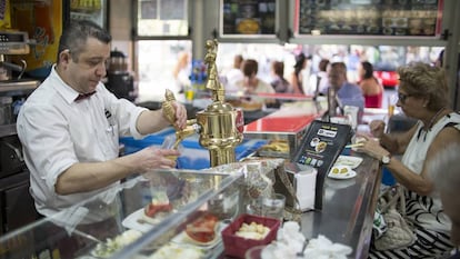 Un camarero tira una caña en un bar de Sevilla.