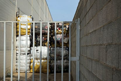 Fardos de ropa usada en un polígono industrial de Montaverner (Valencia), el 21 de febrero. El geolocalizador de un abrigo de paño negro que Planeta Futuro depositó en un contenedor de Valencia indica que la prenda está en este lugar.