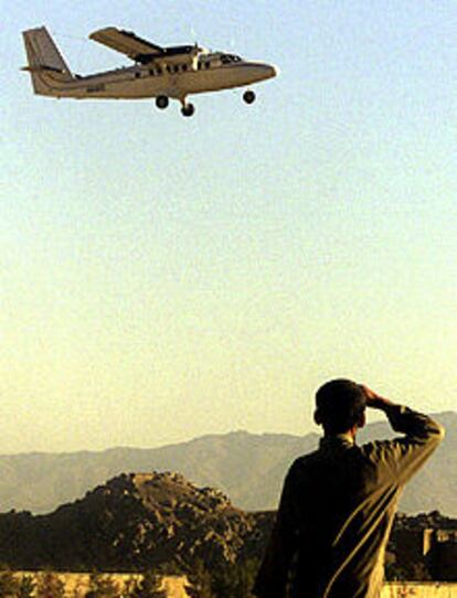 Un niño observa el aterrizaje de un avión sin identificar en una pista de Cherkat.