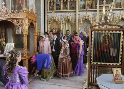 Un grupo de romaníes hace cola para pasar por debajo de un altar en el monasterio de Bistrita, en Costesti, en una tradición que se celebra antes del servicio religioso.