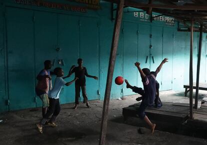 Niños liberianos juegan al fútbol bajo los puestos de un mercado, en Morovia (Liberia).