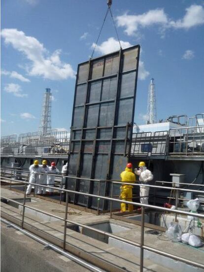 Imagen cedida por la compañía Tepco, operadora de la central de Fukushima, que muestra la instalación, ayer, de una gran vaya metálica que cubra una grieta en la compuerta de una presa y prevenga una nueva salida de agua radiactiva.