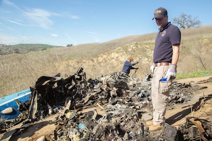 Un investigador inspecciona los restos del helicóptero accidentado en Calabasas, donde fallecieron Kobe Bryant y ocho personas