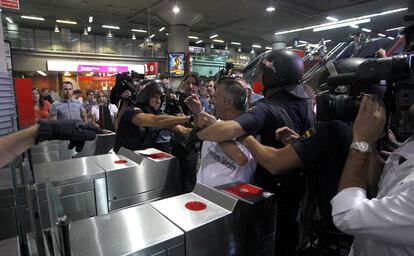 Forcejeo entre policías y trabajadores del ferrocarril en los tornos de la estación de Atocha, Madrid.