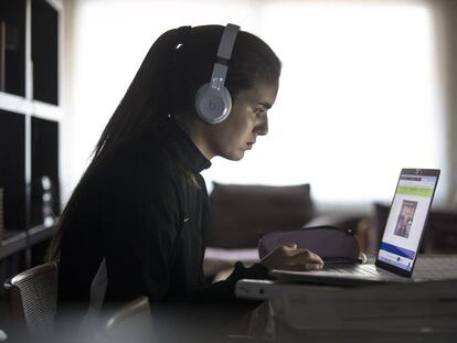 Una jove consulta el seu ordinador durant el confinament.