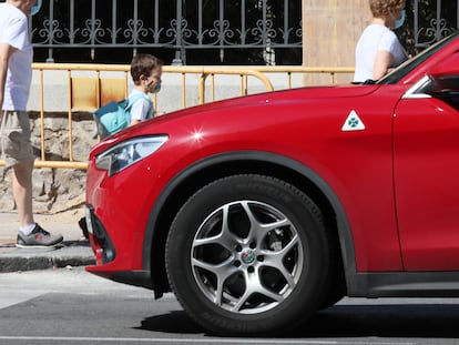 Un niño pasa ante un vehículo tipo SUV.
