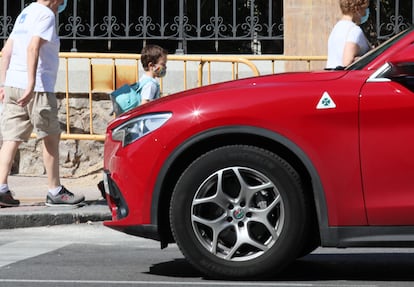 Un niño pasa ante un vehículo tipo SUV.