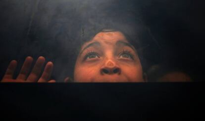 Un niño palestino mira por la ventana de un autobús mientras espera para viajar a Egipto desde el sur de la franja de Gaza.