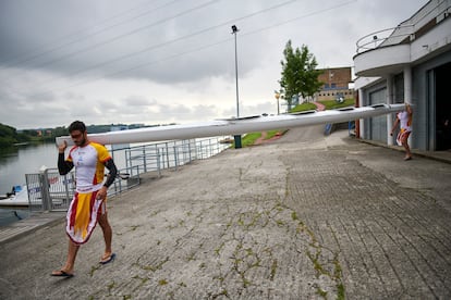 Rodrigo Germade (a la izquierda) y Marcus Cooper bajan la piragua para salir al agua en el embalse de Trasona (Asturias), este junio.