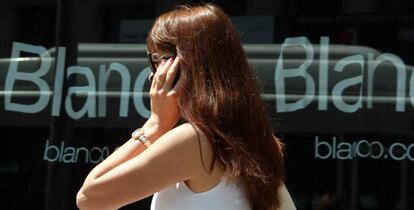 Una mujer habla por tel&eacute;fono en una calle de Madrid.