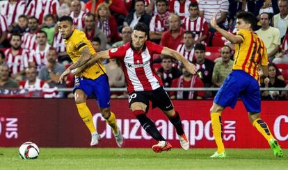 Aduriz disputa el bal&oacute;n con Dani Alves y Bartra.