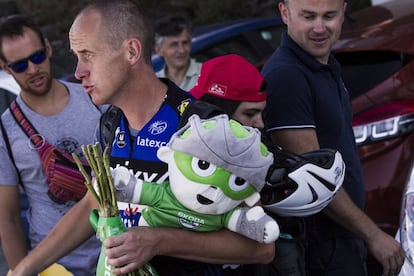 Uno de los asistentes del Etixx-Quick Step lleva al autobús del equipo los premios y el caso de Gianni Meersman, ganador de la segunda etapa de la Vuelta.
