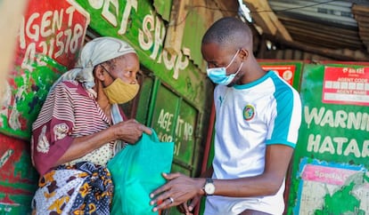 Una residente de Mathare recibe una bolsa con alimentos de Billian.