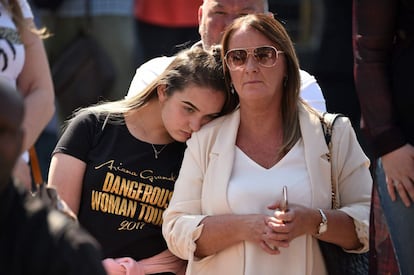 Una mujer con la camiseta de Ariana Grande reacciona frente a la Catedral de Manchester. 