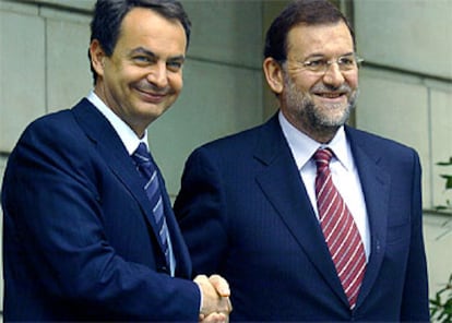 Zapatero y Rajoy se saludan momentos antes de entrar en el Palacio de La Moncloa.