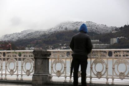 Un hombre observa la nieve caída en San Sebastián. 