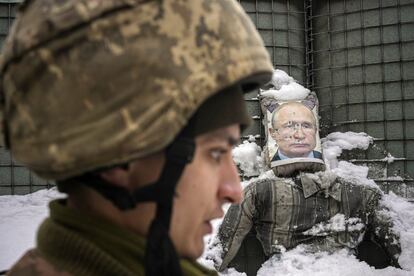 Un militar ucranio, al fondo un muñeco con el rostro de Putin acribillado a balazos.