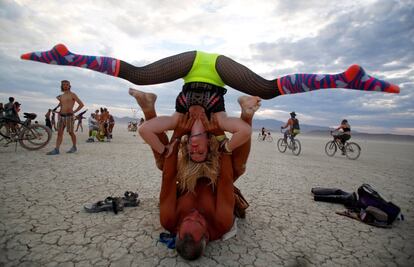 Dos visitantes practican acro-yoga en el festival Burning Man, en el desierto de Black Rock de Nevada (EE UU). 