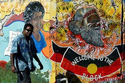 Un aborigen australiano pasa por delante de un mural de arte indígena en Redfern, un barrio periférico de Sidney.