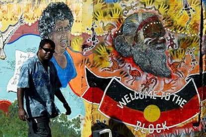 Un aborigen australiano pasa por delante de un mural de arte indígena en Redfern, un barrio periférico de Sidney.