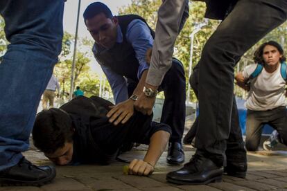 Membros da Polícia Científica prendem um manifestante, durante uma marcha convocada pela oposição, em Caracas (Venezuela).