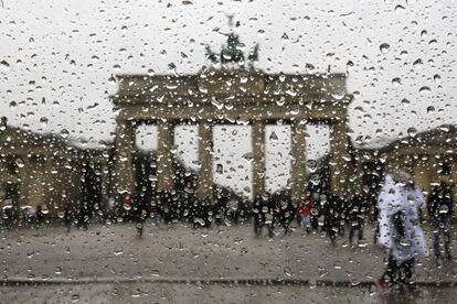 La ventana de un coche está cubierta con gotas de lluvia delante de la puerta de Brandeburgo en un día de primavera lluvioso en Berlín (Alemania).