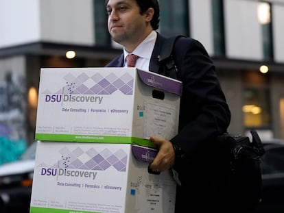 Documents related to the class-action lawsuit on behalf of investors who owned Tesla stock in August 2018 are carried toward a federal courthouse in San Francisco, Friday, Jan. 20, 2023.