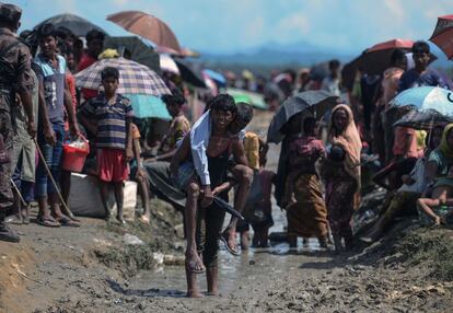 Un refugiado rohingya transporta a hombros a un anciano cerca de la frontera de Bangladés después de cruzar el río Naf.