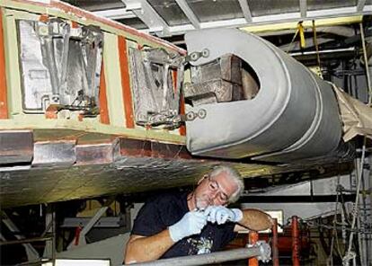 Un técnico de la base espacial Kennedy, en Florida, revisa un ala del transbordador Atlantis, con los nuevos paneles curvos de carbono rezorzados.