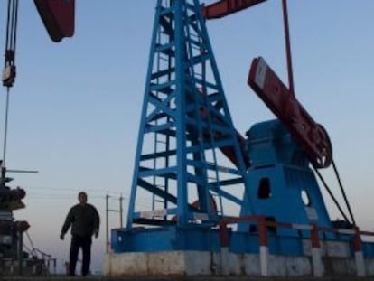 Un trabajador bajo un pozo de petróleo.
