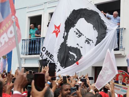 El candidato presidencial Lula junto a una enorme bandera con su imagen de una ficha policial de los ochenta, este domingo en un mitin en Río de Janeiro.