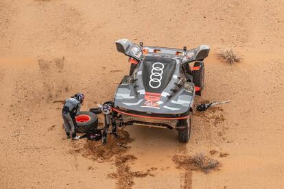 Carlos Sainz y Lucas Cruz, reparando una avería de su vehículo durante la tercera etapa del Rally Dakar este martes.