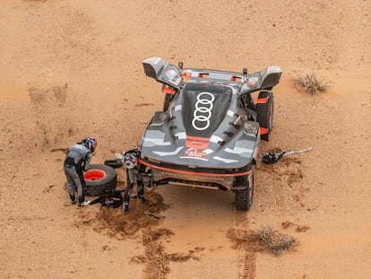 Carlos Sainz y Lucas Cruz, reparando una avería de su vehículo durante la tercera etapa del Rally Dakar este martes.