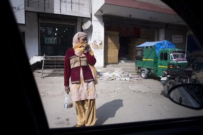 "Cuando la tradición y la norma se convierten en desprecio y degradación". 
Una mujer con la cabeza y el rostro tapado observa lo que sucede a su alrededor en Delhi.

