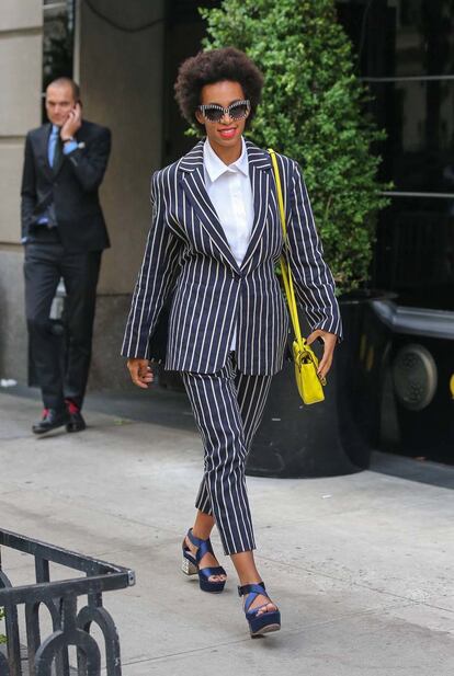 Solange Knowles es una de nuestra favoritas con este tuxedo a rayas que combinó con tonos llamativos: satchel neón y sandalias satinadas azul noche.