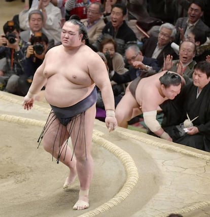 Ozeki Kisenosato (i) vuelve al ring tras haber derrotado al gran campeón de Mongolia, Hakuho, durante la final del Gran Torneo Anual de Sumo, en Tokio (Japón).